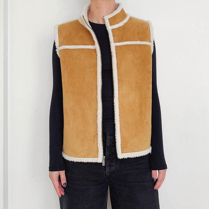 Tan vest with cream shearling trim worn with black shirt and jeans
