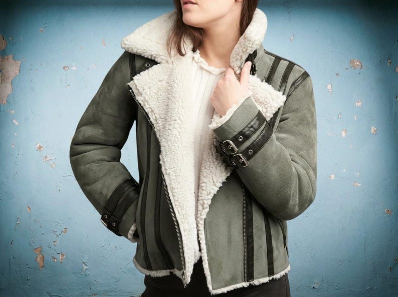 Woman wearing suede aviator biker jacket with white faux fur lining
