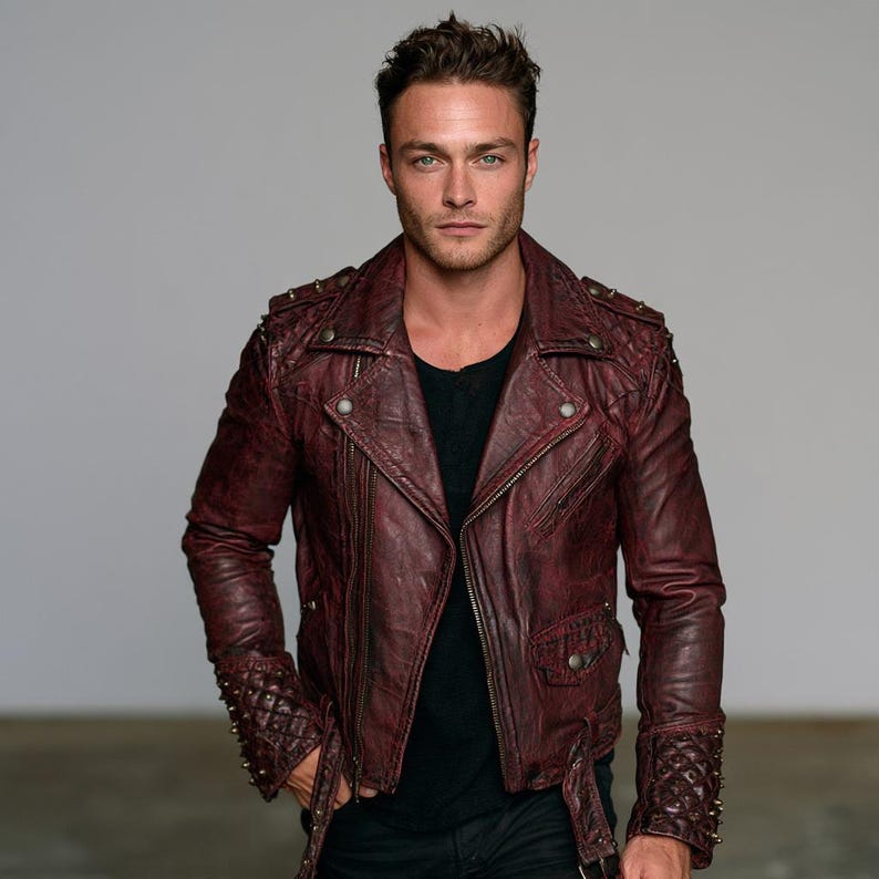 Men's maroon leather biker jacket with studded shoulders, snap lapels and waist belt