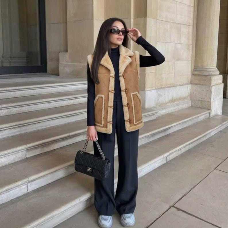 Woman wearing camel suede shearling-trim vest with sneakers